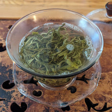 Hui Long green tea in hot water, in a glass gaiwan